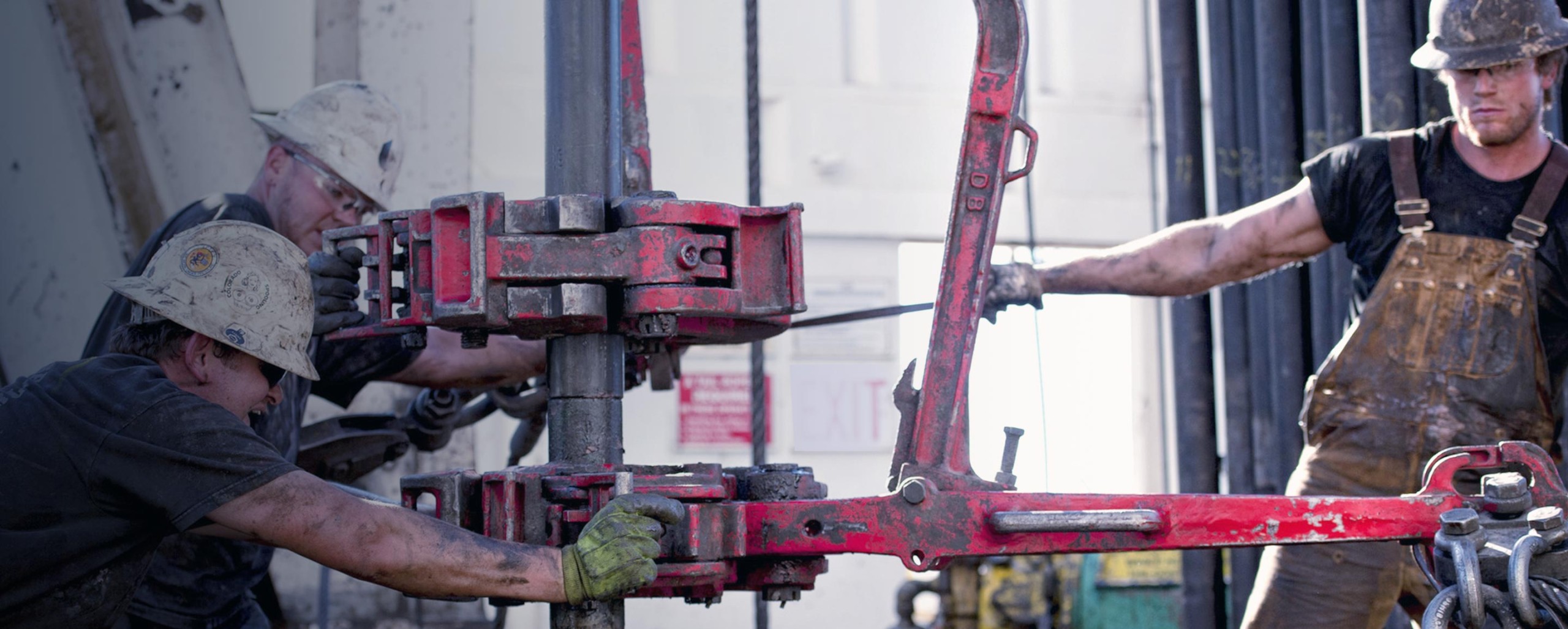 Red metal scaffolding beams and a crane arm at a construction site.